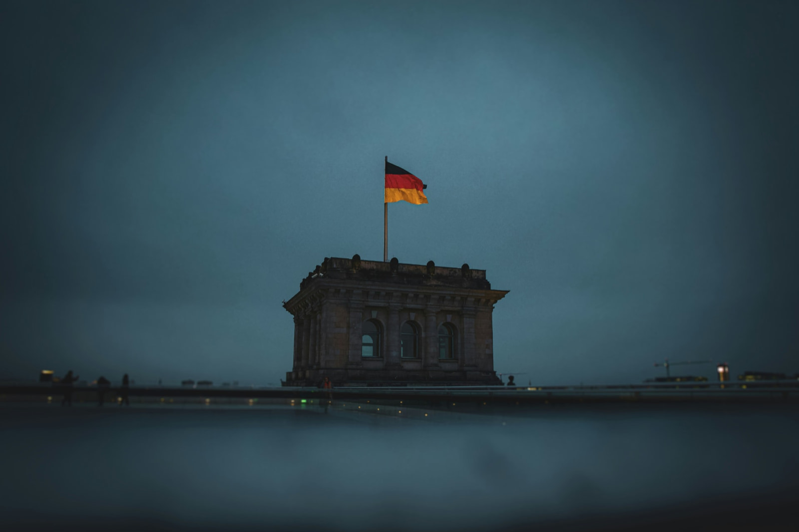 German flag flying above the Reichstag at dusk