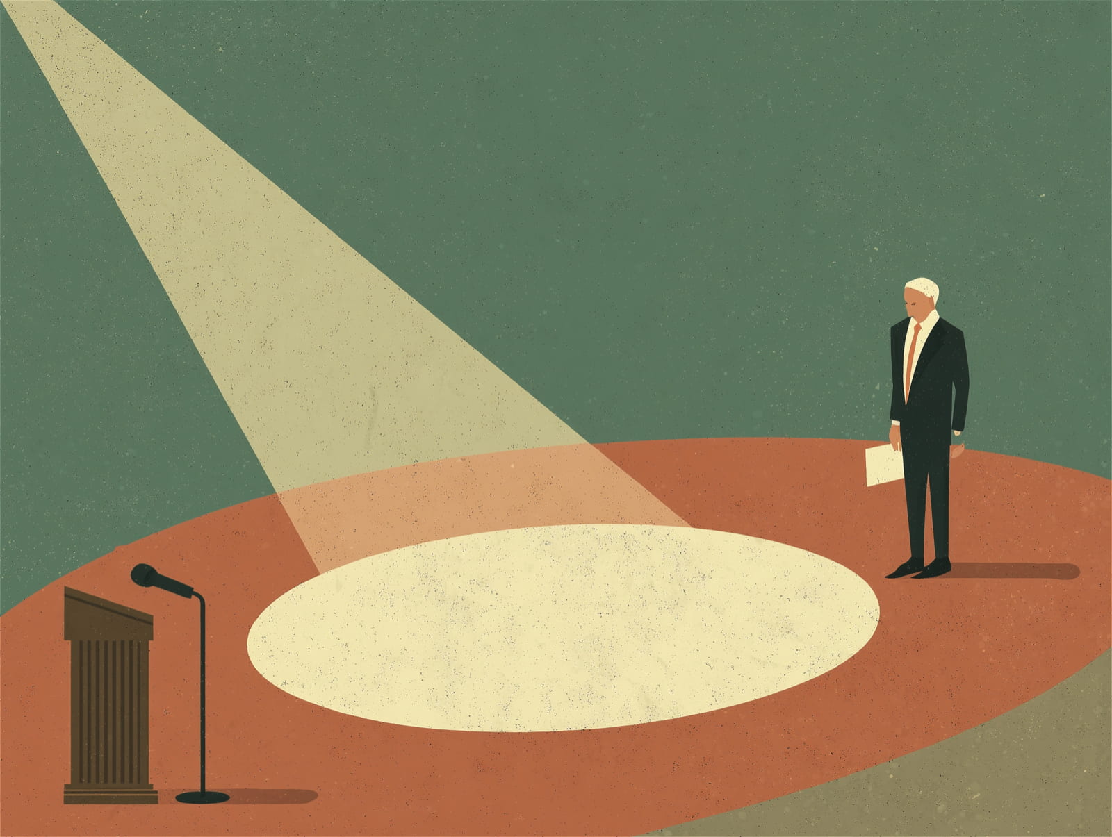 A speaker stands alone on a spotlighted stage beside a microphone and lectern.